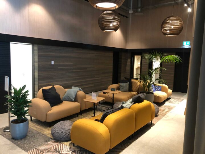 Lounge area featuring yellow sofas, a coffee table, and decorative plants in a modern interior design.