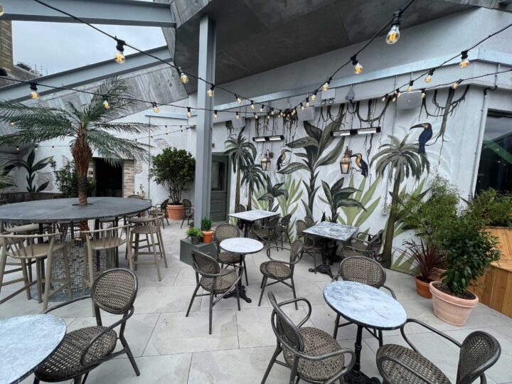 Chic rooftop patio with tables and tropical decor ambiance