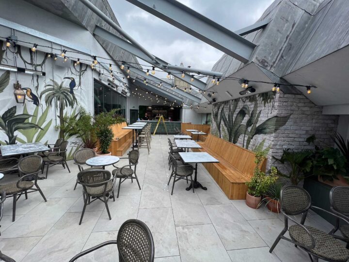 Rooftop terrace with seating and plants under cloudy sky