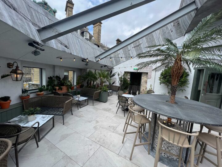 Rooftop terrace with seating and plants under cloudy sky