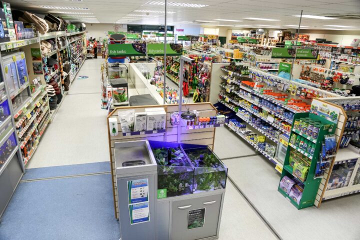 Pet supply store interior with various products on display shelves